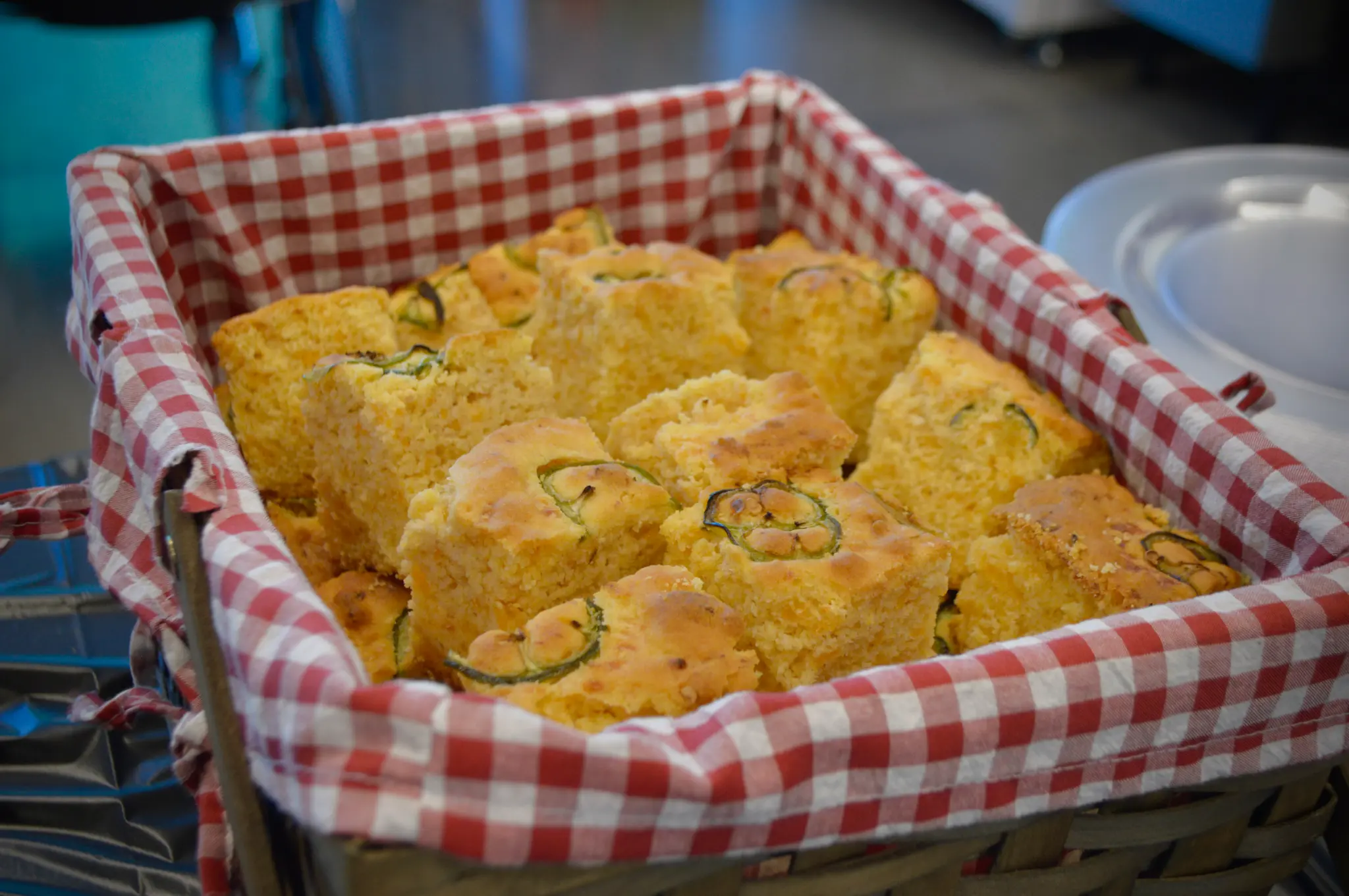 Jalapeño cornbread squares in a red-checkered basket