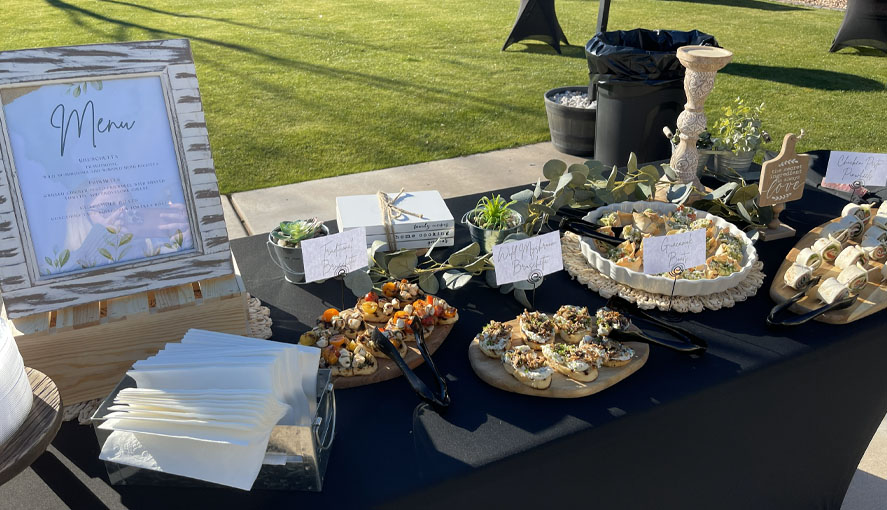 Bruschetta and crostini appetizer station with menu signage and fresh herbs